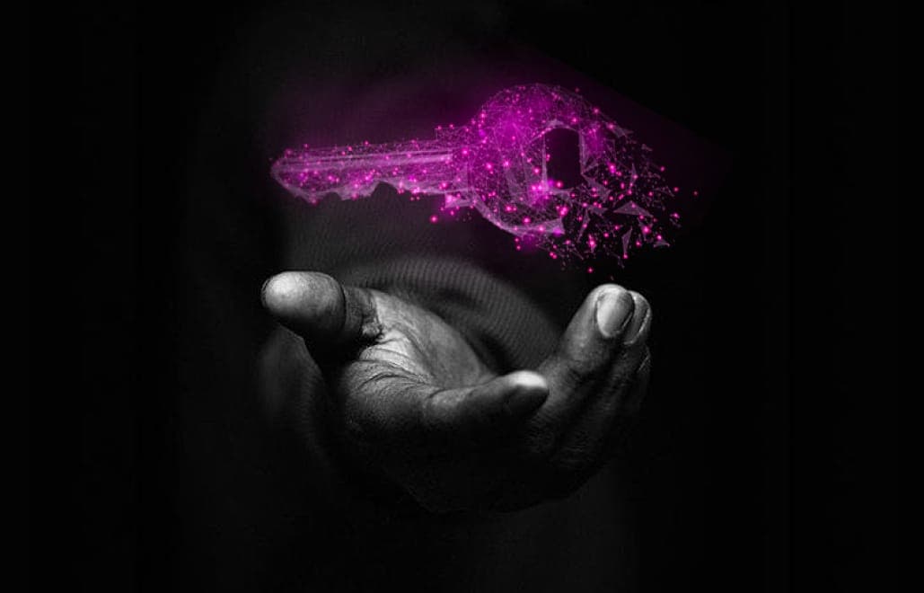 A glowing digital key floating above an open hand